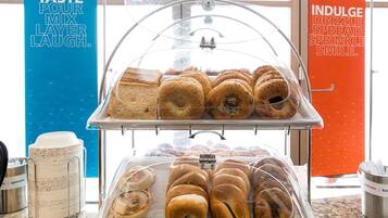A bakery display with various baked goods, a coffee maker, and utensils.