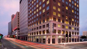 A multi-story hotel with a brick facade, large windows, and a ground-level entrance. - Hampton Inn & Suites Dallas Downtown (Dallas)