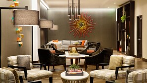 A modern interior with a sofa set, a coffee table, and a unique wall decoration. - Hampton Inn & Suites Dallas Downtown (Dallas)