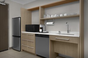 A modern kitchen with a built-in refrigerator, microwave, coffee maker, and dishwasher. - Home2 Suites by Hilton Louisville East/Hurstbourne (Louisville)