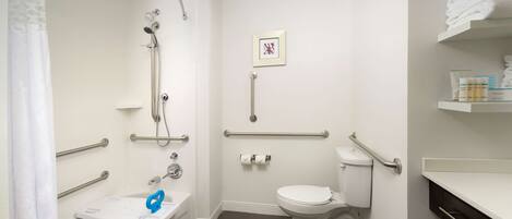 A bathroom with a shower, toilet, and sink.