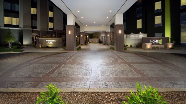 En hotelindgang med et moderne design, hvor en central sti fører til receptionen.
