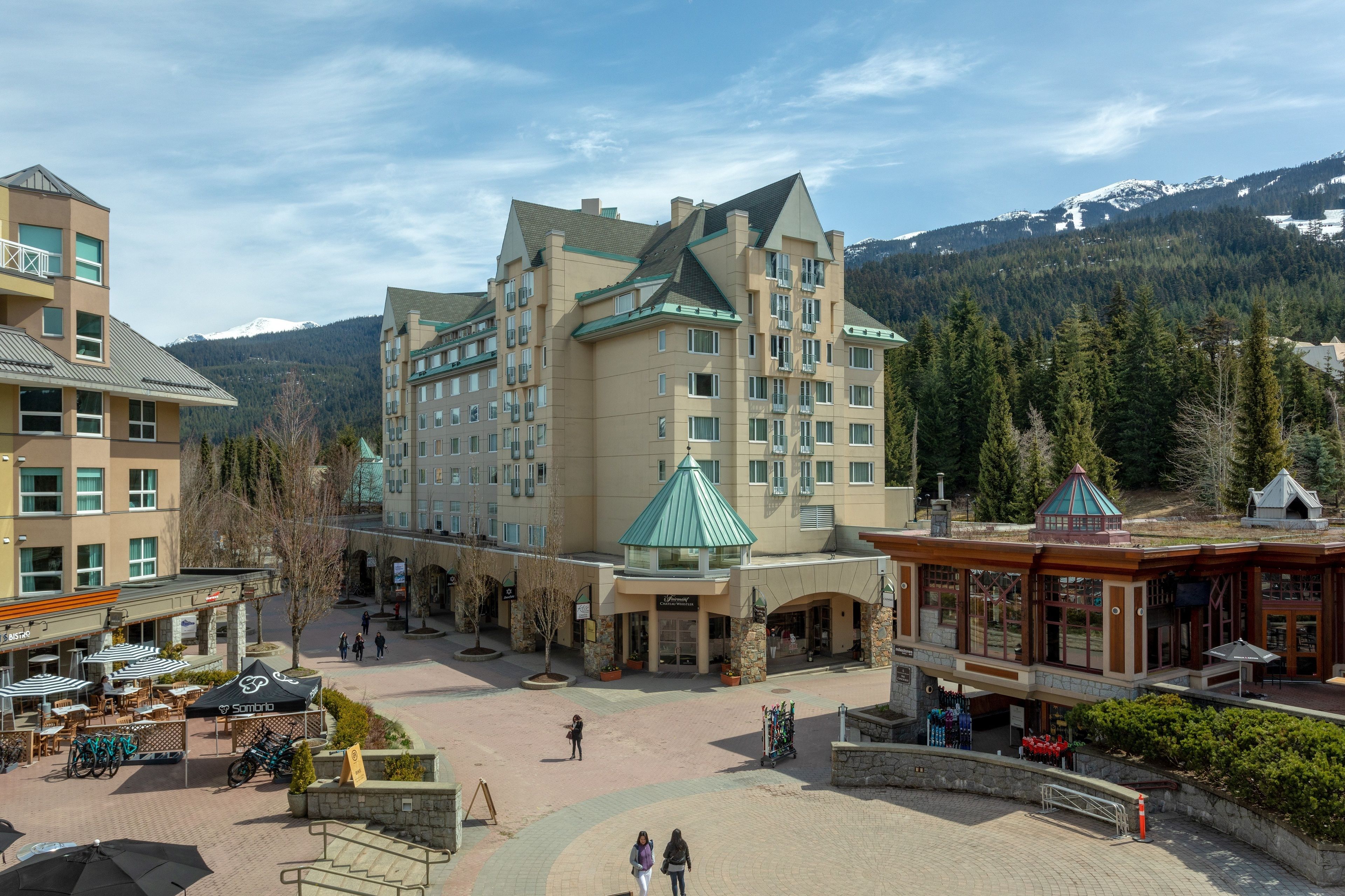 A hotel with a central courtyard, multiple floors, and a mountain backdrop.
