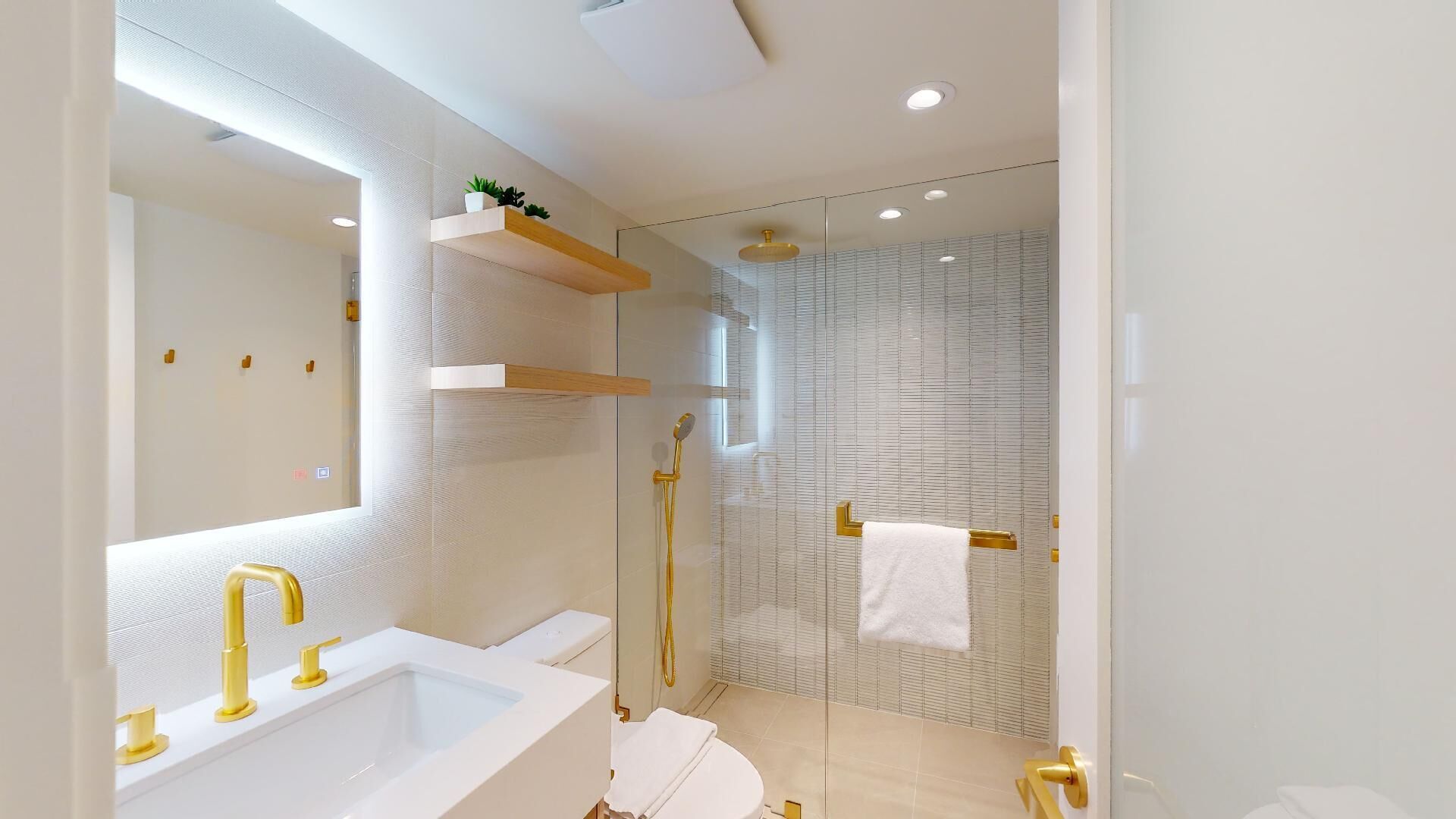 Een moderne badkamer met een grote spiegel, een badkuip, een douche en een douchecel met glazen wanden.