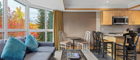Une cuisine moderne équipée d’un four à micro-ondes, de meubles en bois et d’un coin repas avec des chaises et une table.