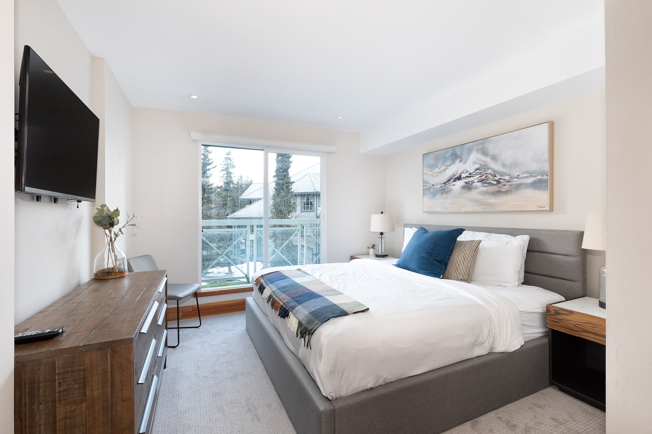 Une chambre moderne avec un grand lit, un bureau et un téléviseur.