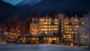 A hotel with multiple floors, large windows, and a snow-covered landscape in the background.