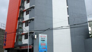 Ein hohes Hotel mit roter und grauer Fassade, mehreren Balkonen und einem Schild, das 388 Zimmer bewirbt.