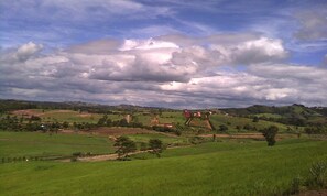 A rural landscape with rolling hills, scattered houses, and a cloudy sky. - Khao Kho Boutique Camps (Khao Kho)