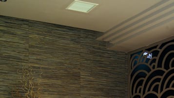 Guests can unwind in a peaceful indoor space with a comfortable bench and calming ambiance.