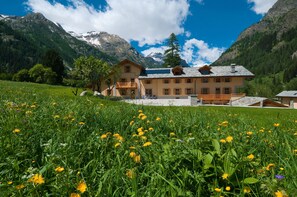A mountain lodge with a large balcony, surrounded by lush greenery and mountains. - Villa Fridau (Gressoney-Saint-Jean)