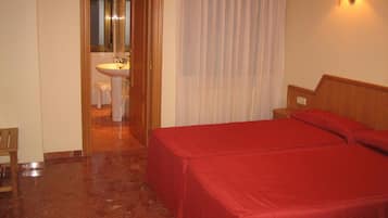 Een bureau, verduisterende gordijnen, een strijkplank/strijkijzer