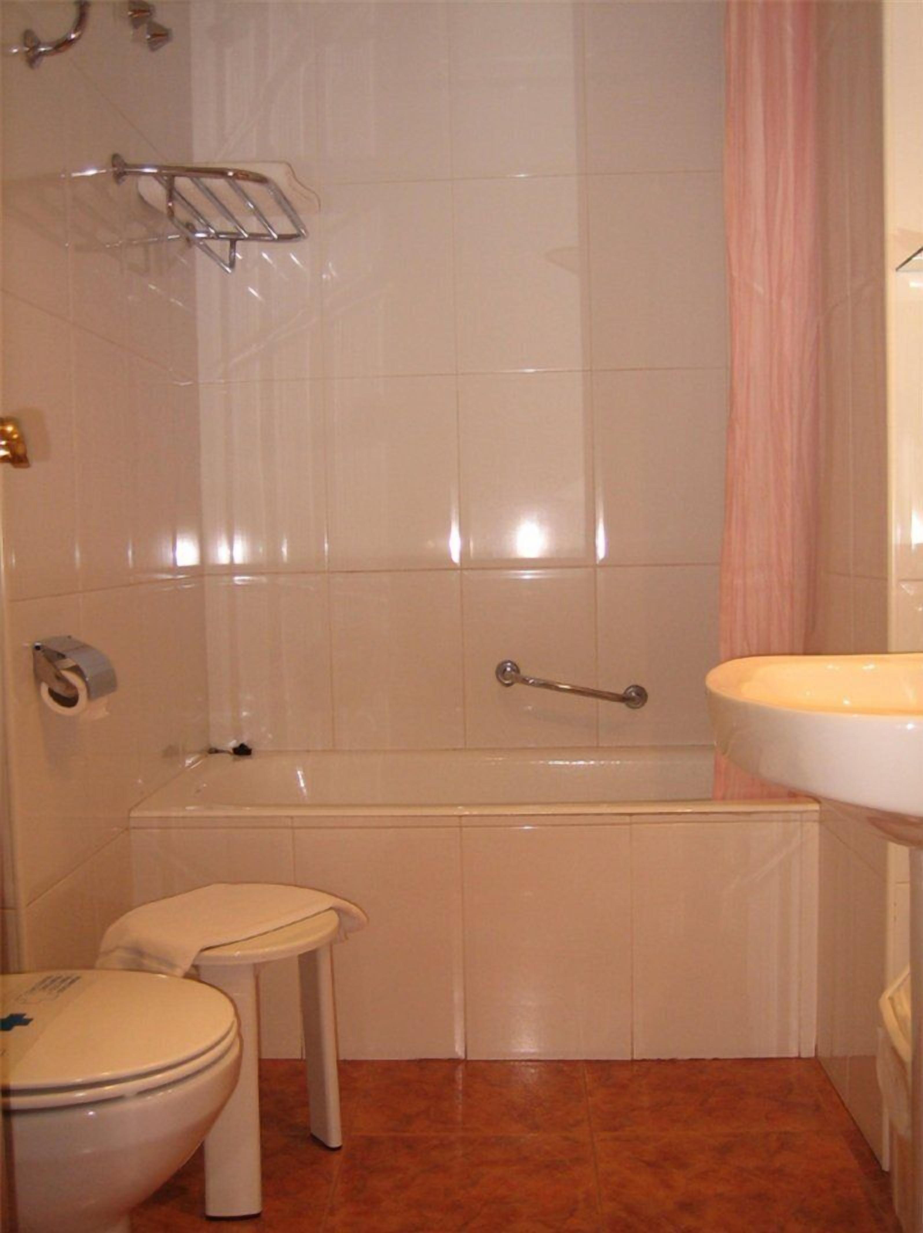 Un baño con inodoro, lavamanos y bañera.