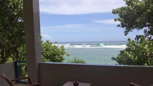 A balcony with wooden furniture and a view of the ocean. - Paradise Beach Resort (Thalaramba)