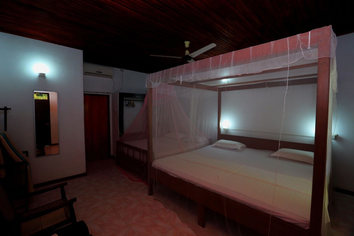 Una habitación con literas, un espejo, un ventilador de techo y una puerta.