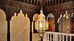 Un intérieur richement décoré, avec des sculptures complexes sur les murs et un lustre suspendu.