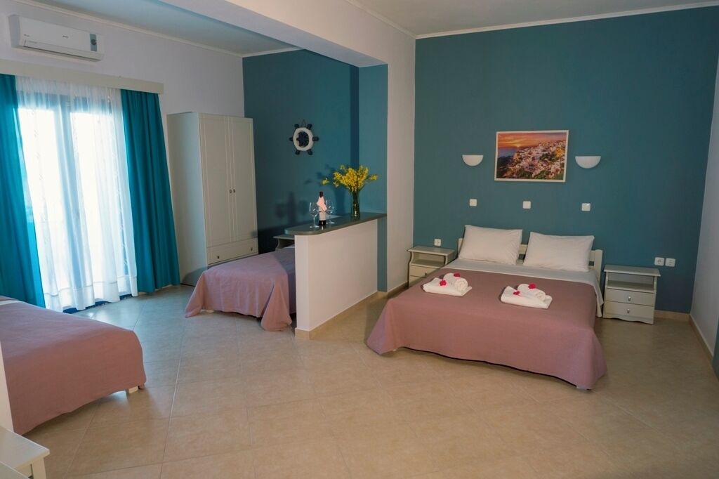 Habitación de hotel con dos camas, un escritorio, un armario y un cuadro en la pared.