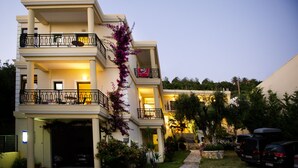 Un edificio de varios pisos con balcones, un garaje y un jardín.