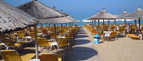 Sur la plage, chaise longue, parasol, serviettes de plage