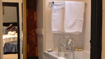 A narrow bathroom with a bathtub, a towel rack, and a mirror.