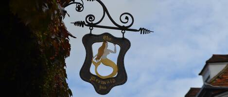A sign with a mermaid silhouette and the text "The Mermaid Inn."