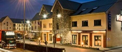 Vista frontal de la propiedad por la tarde o noche