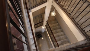 A view of a marble staircase with a wooden handrail and metal balusters, leading to an upper floor. - Casual Stay Galileo  (Reggio Calabria)