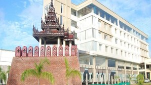 Un edificio moderno con una estructura de templo tradicional al frente.
