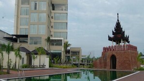 Un hotel moderno con piscina y una estructura de templo tradicional.