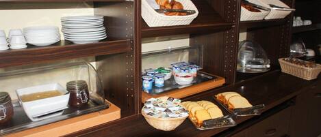 A buffet setup with various food items and condiments.