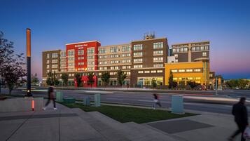 Un hotel de varios pisos con una fachada destacada en rojo y beige, numerosas ventanas y techo plano.