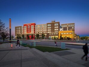 Un hotel de varios pisos con una fachada destacada en rojo y beige, numerosas ventanas y techo plano.