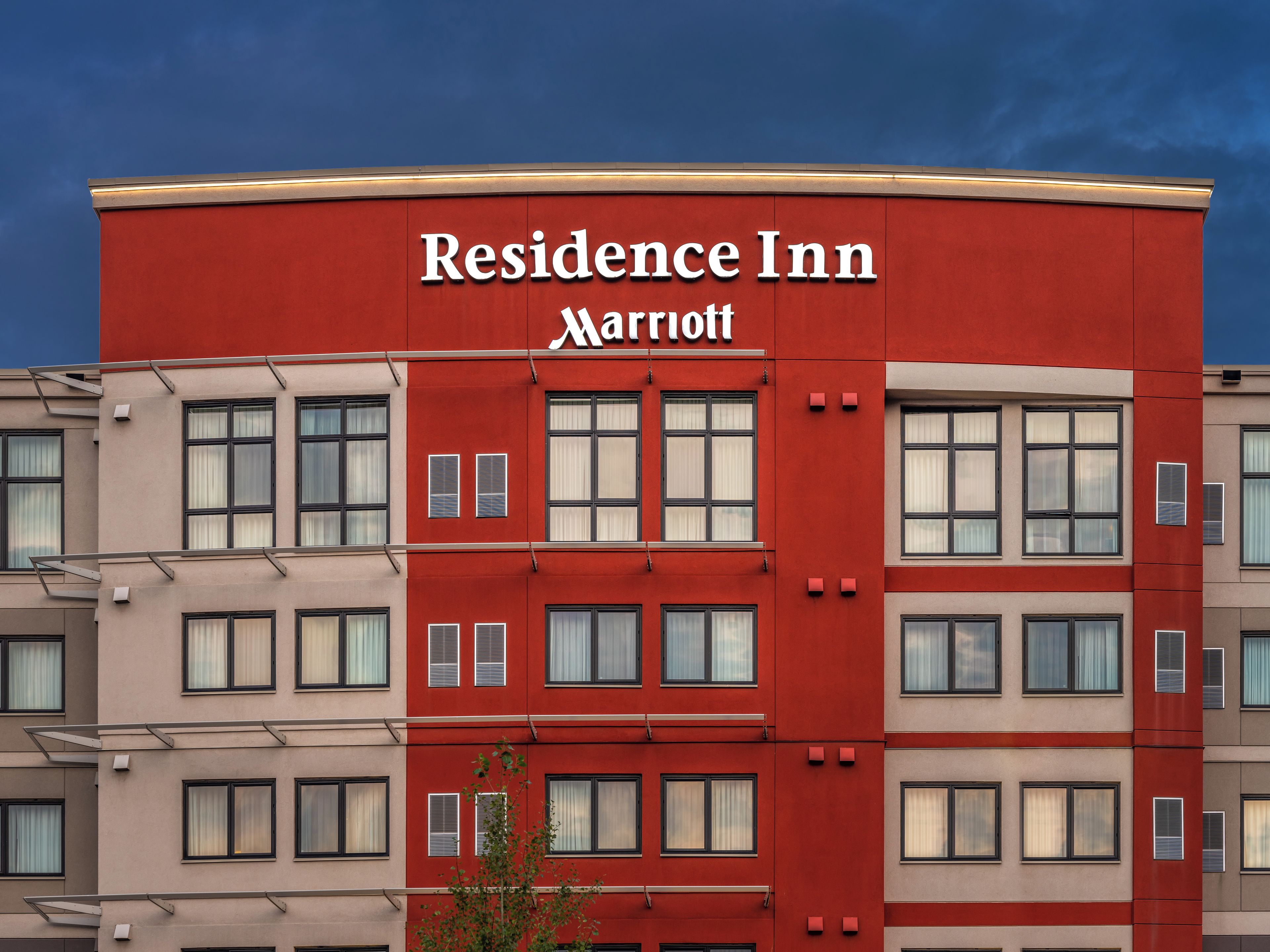 A multi-story building with a red facade and the 'Residence Inn Marriott' sign.