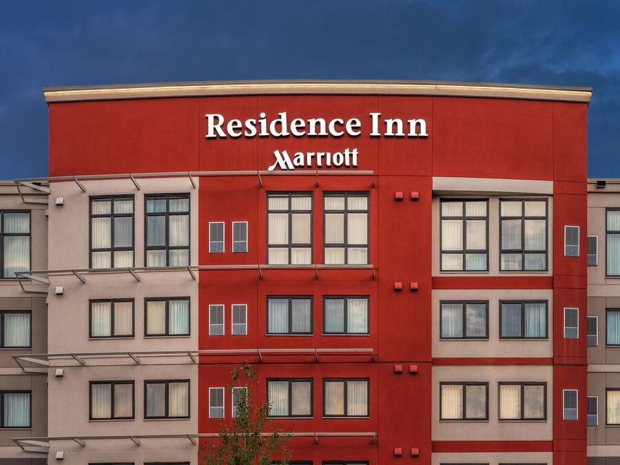 A multi-story building with a red facade and the 'Residence Inn Marriott' sign.