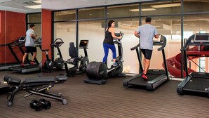 Ett gym med löpband, vikter och träningsbollar.