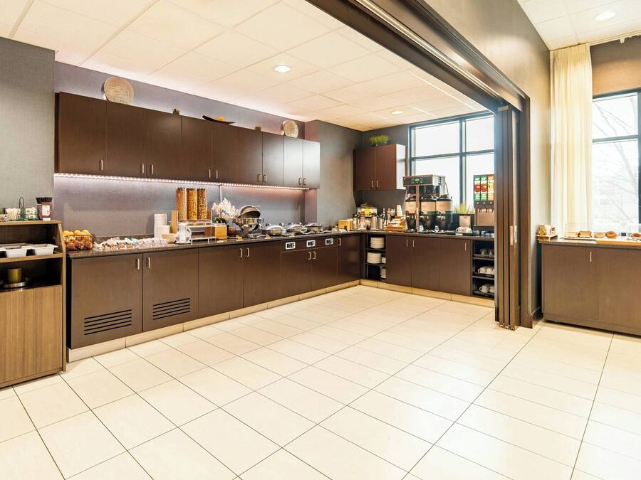 A modern kitchen with dark wood cabinets, a coffee machine, and a large window.