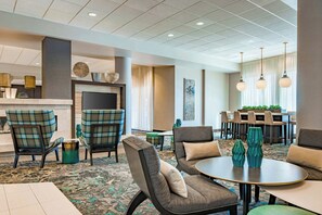 Un hall de hotel con chimenea, zona de estar y comedor.