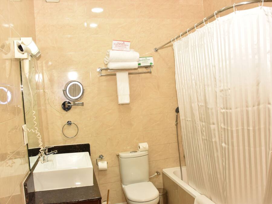 Un baño con lavamanos, inodoro y cortina de ducha.