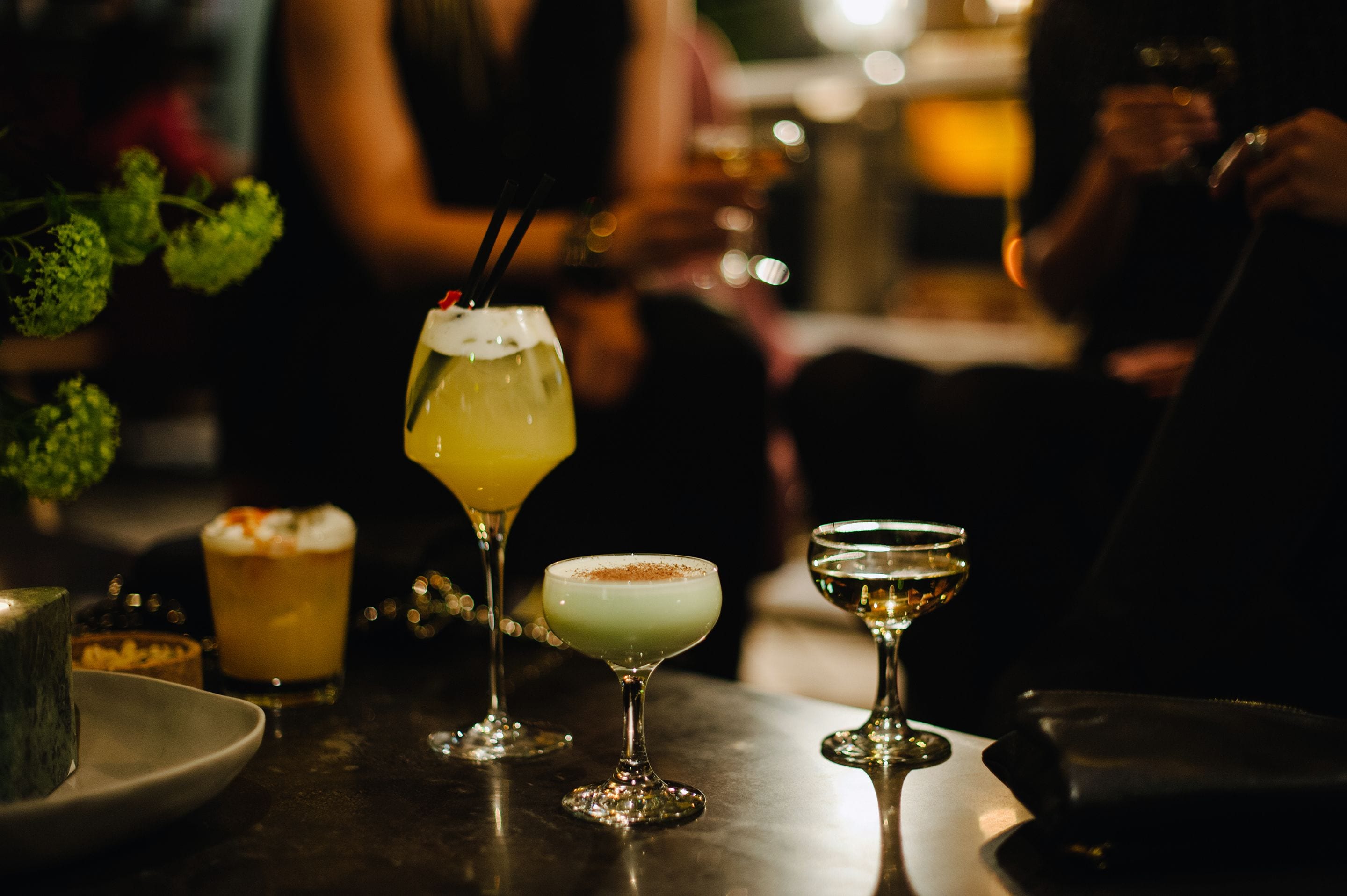 A bar setting with various cocktails in glasses.