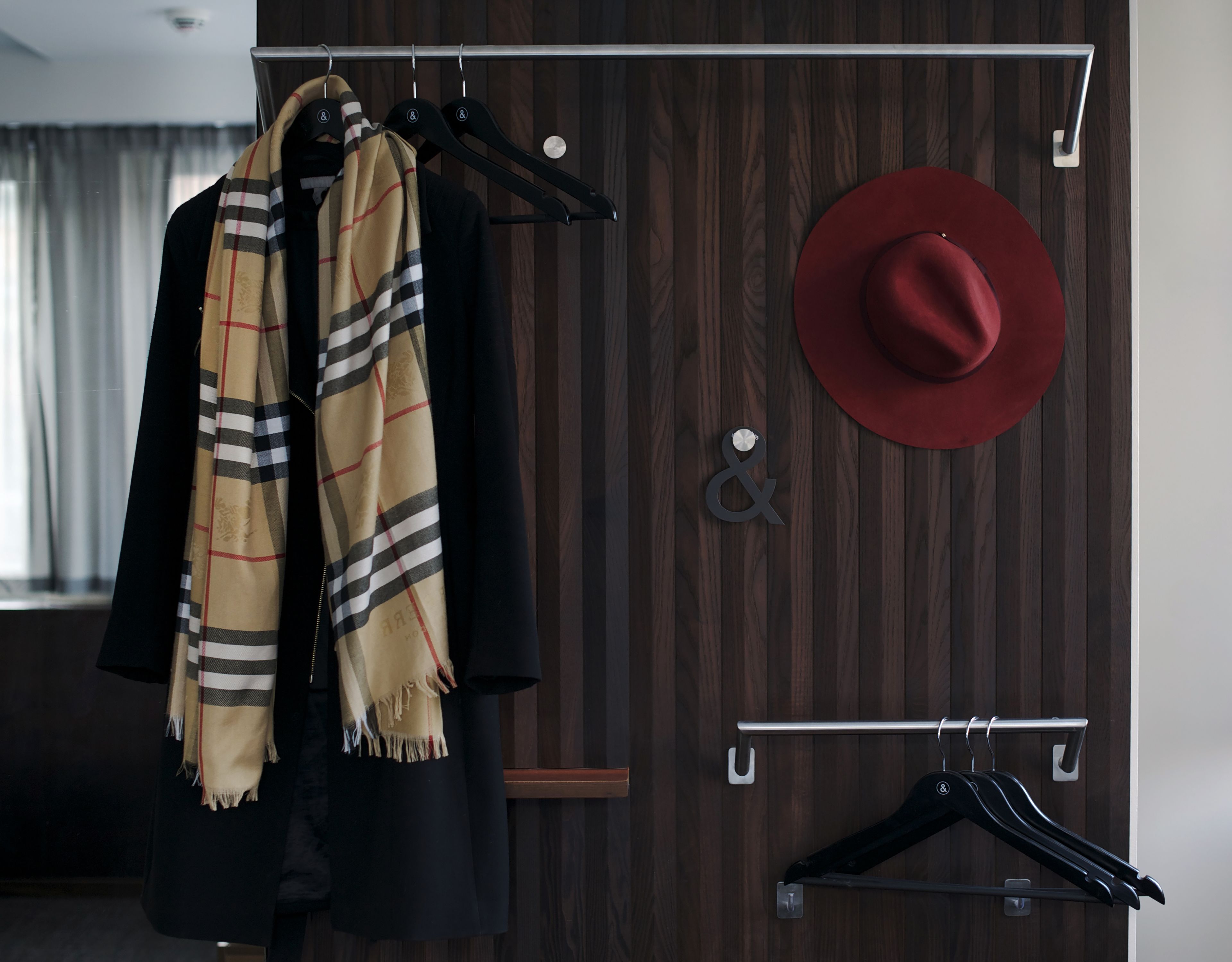 A wooden wardrobe with a hanging rod and a hat rack.