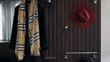A wooden wardrobe with a hanging rod and a hat rack.