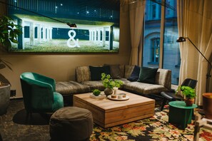 Uma sala de estar moderna com um sofá, uma mesa de centro e uma televisão exibindo um edifício.
