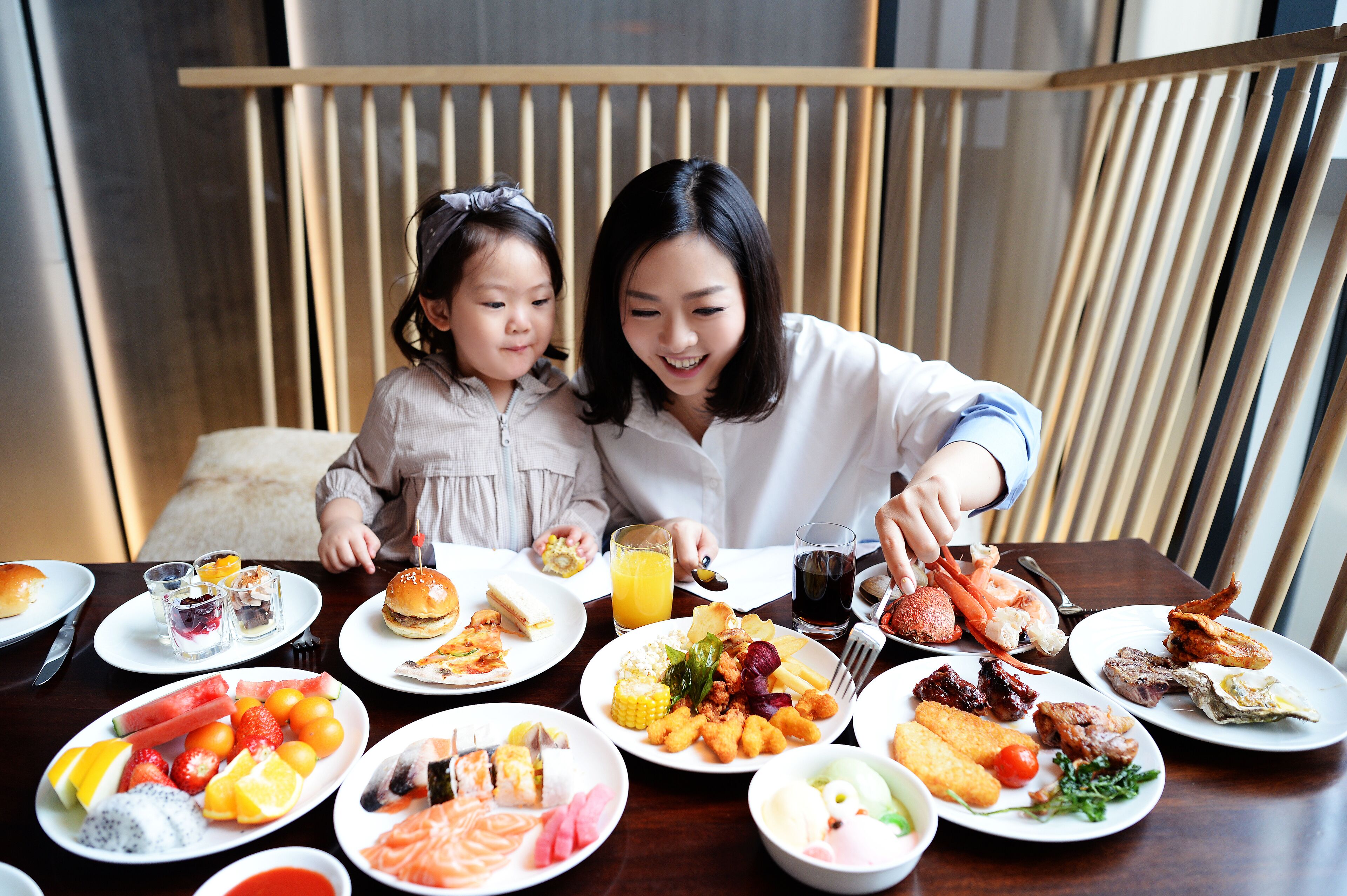A dining table with various dishes, including seafood, vegetables, and fruits.