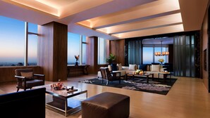 Un vaste espace de vie agrémenté d’une grande fenêtre donnant sur la ville, d’un coin salon confortable et d’un design moderne.