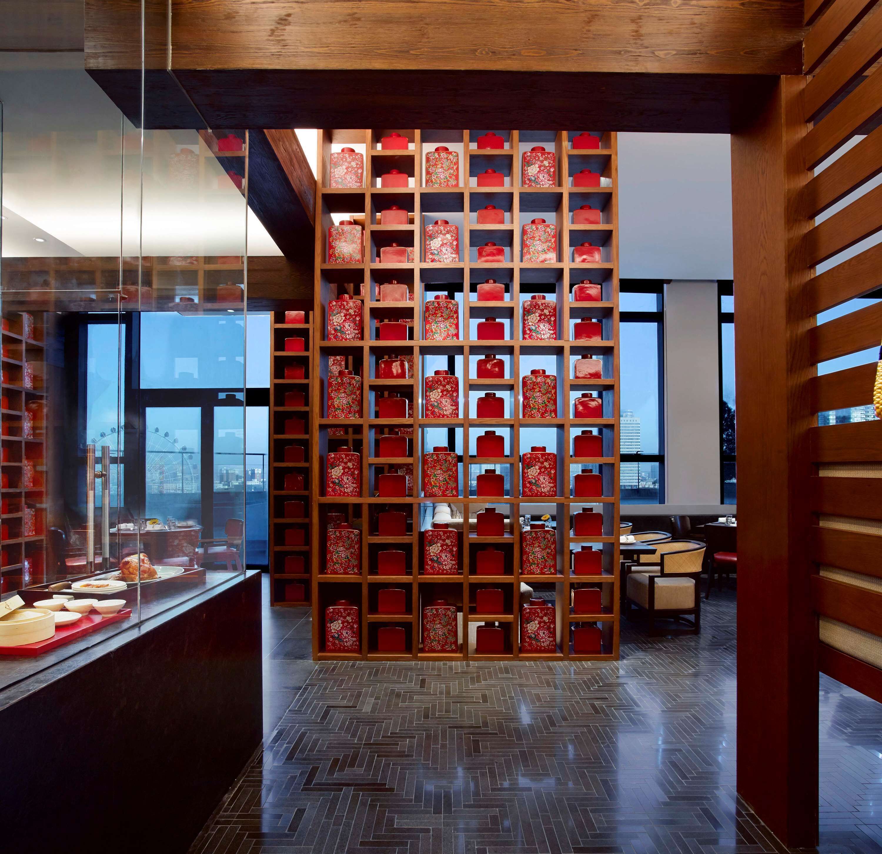 A modern interior with a wooden partition displaying red containers.