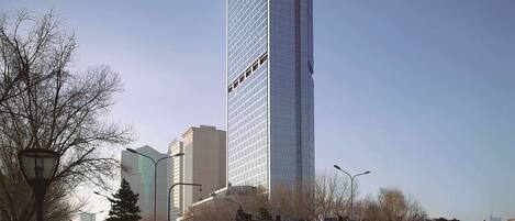 En høj, moderne skyskraber med en glasfacade og navnet "HYATTREGENCY" øverst.