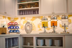A kitchen with shelves stocked with condiments, a fruit bowl, and a coffee machine. - Hyatt Place San Juan (San Juan)