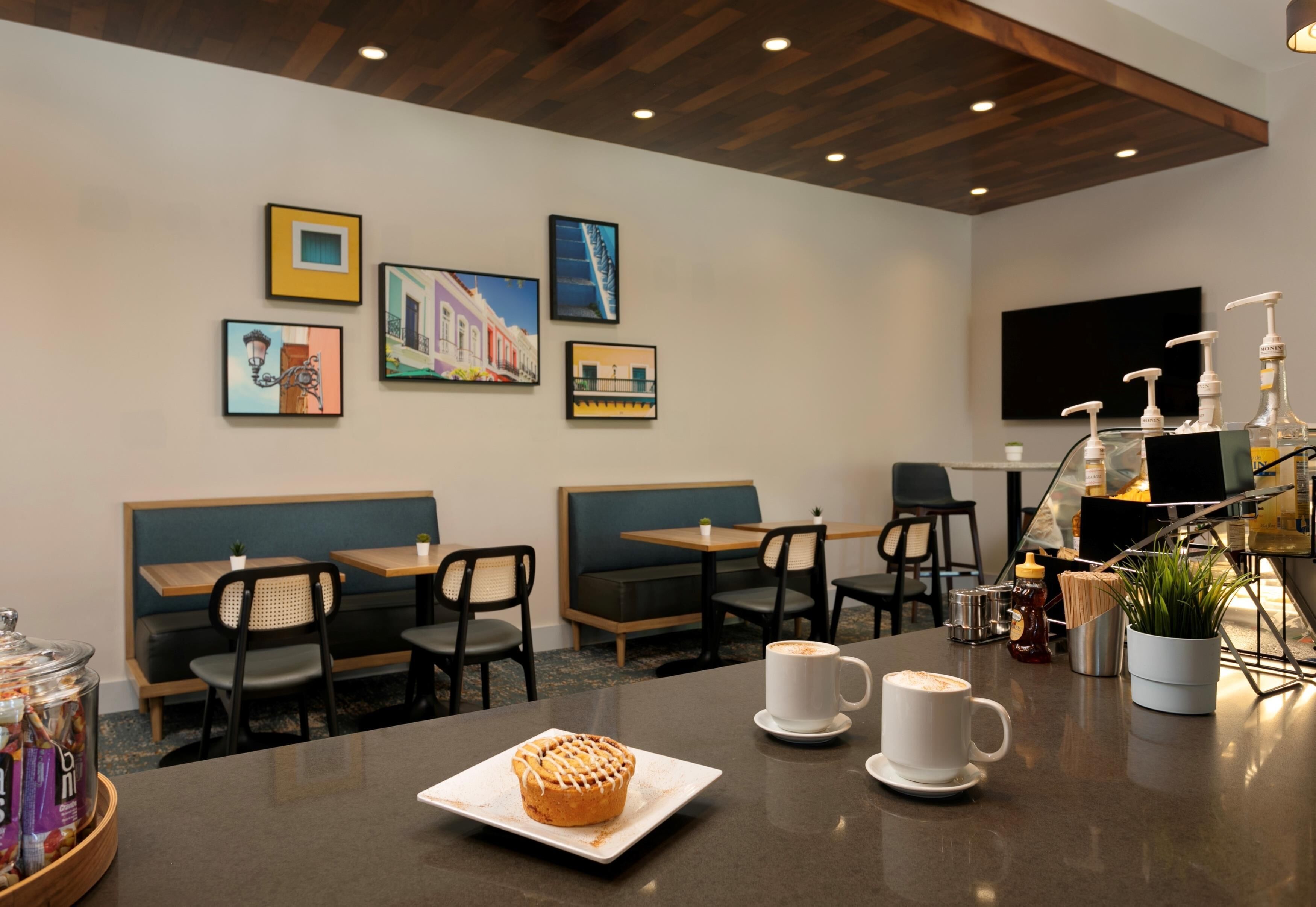 A hotel dining area with booths, tables, and a coffee station.