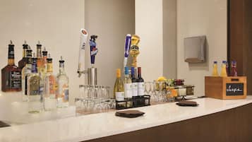 Una zona de bar con diversas botellas y vasos, incluyendo una selección de vinos y licores.