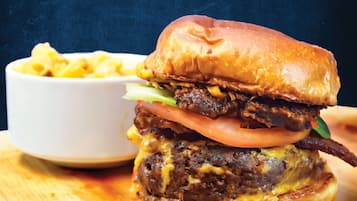 A burger with a side of macaroni and cheese.